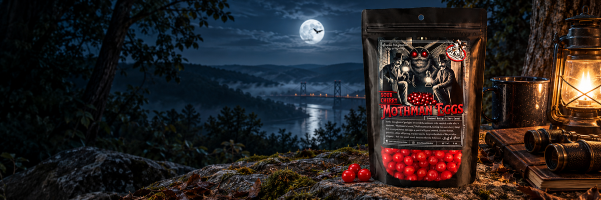 Duff & Shaw Sour Cherry Mothman Eggs beside a lantern overlooking a moonlit river and bridge.